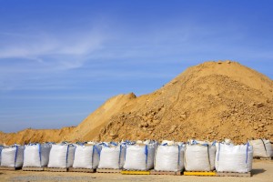 FIBC sandbags outside in front of giant sand pile